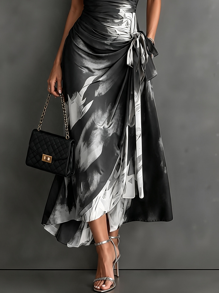 Maddie | Midi wrap dress with abstract red-black print, V-neck, short sleeves, tie belt, and asymmetrical ruffle hem